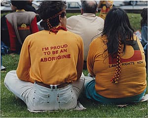 Michael RILEY | 'I'm proud to be an Aborigine' [Couple in t-shirts, photographed from back]